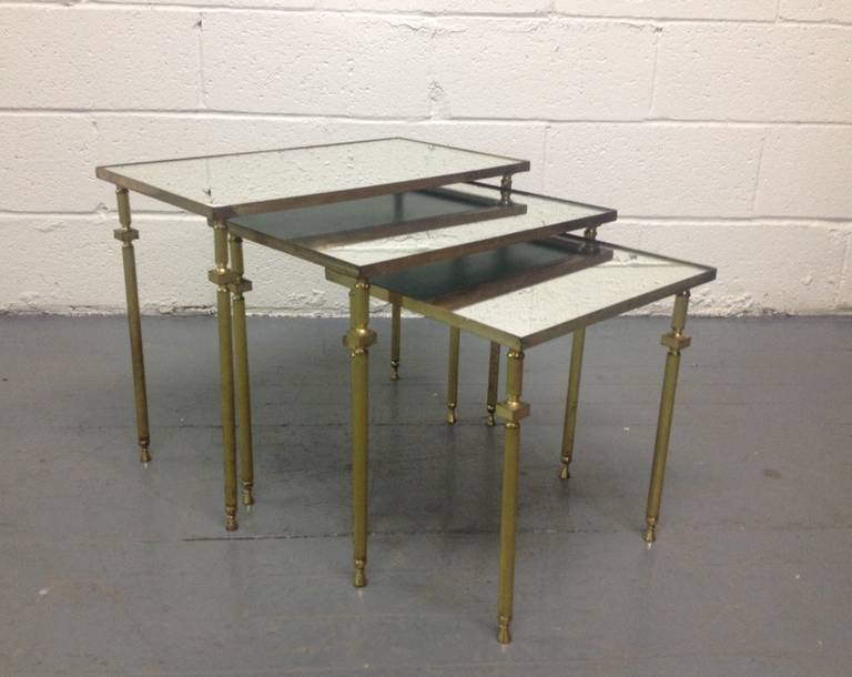 Ce nid de tables est doté d'un plateau en miroir, de pieds en bronze et d'une garniture en bronze autour des plateaux. 
La table la plus grande mesure : 17.25