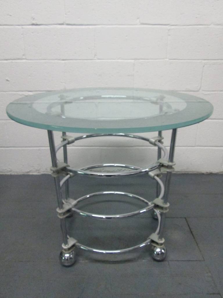 Chromed steel base is held together with cast aluminum brackets. Round feet, also in chrome. Glass top is clear with an acid etched border.  For Century Furniture.