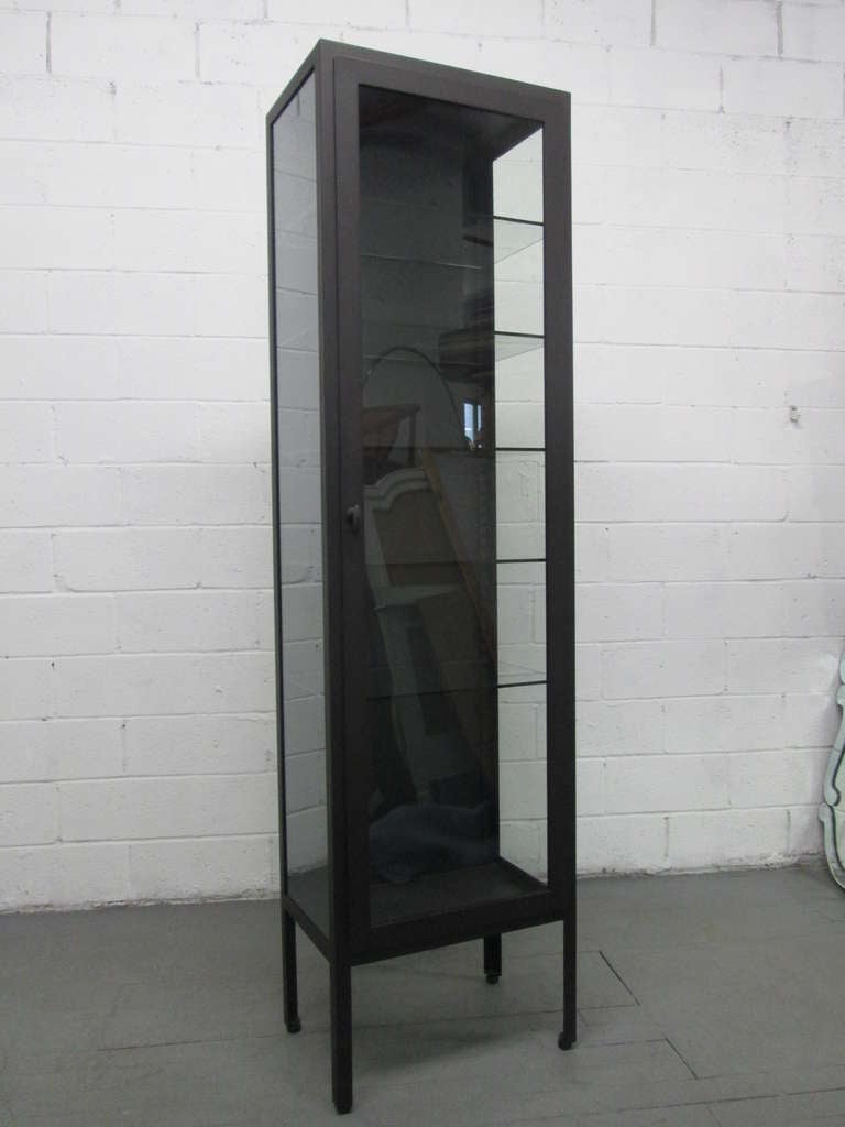 Tall Industrial Painted Metal and Glass Display Cabinet.   Cabinet has glass adjustable shelves and glass on the sides of the cabinet.