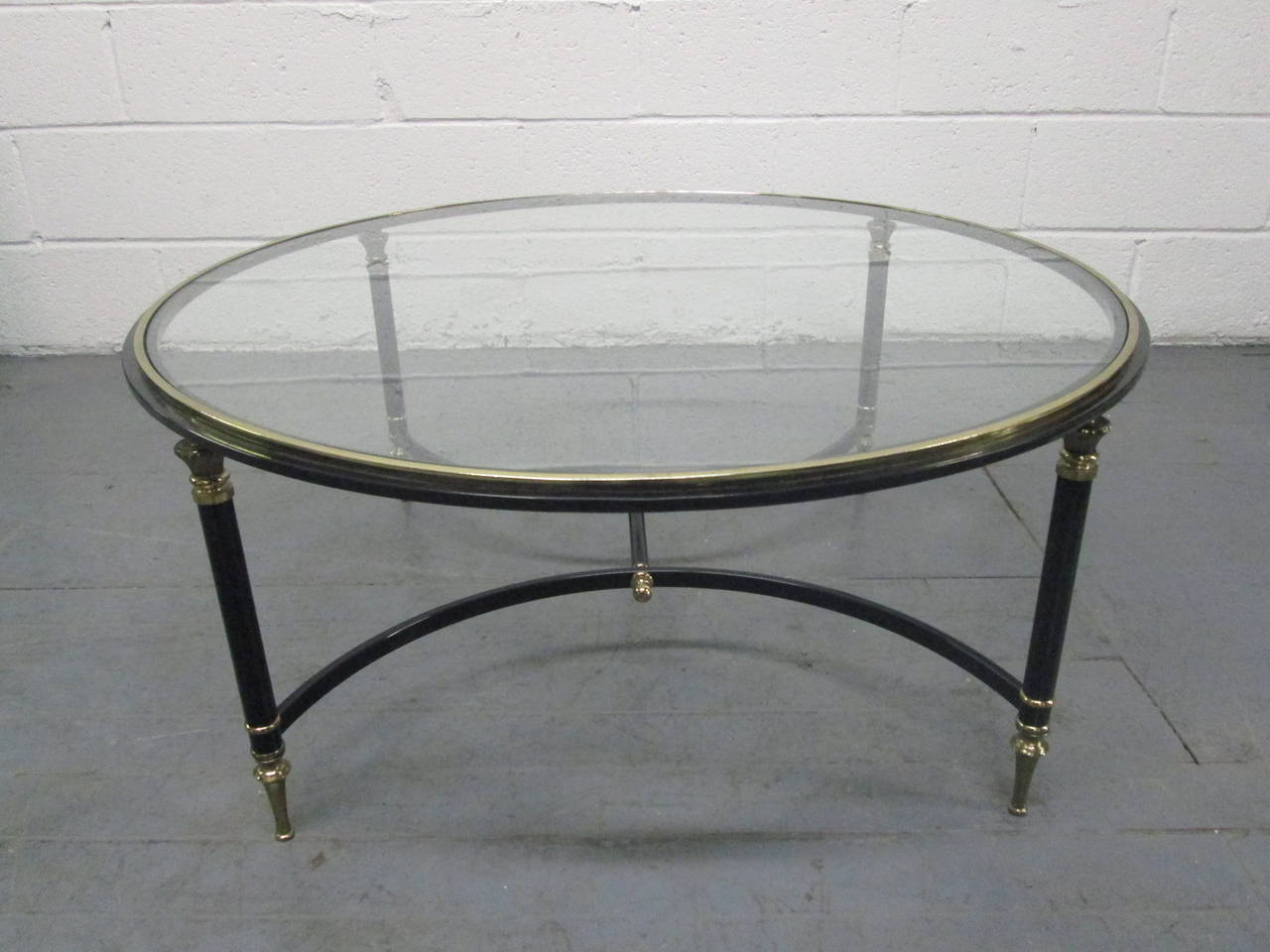 French coffee table style of Maison Jansen. Black lacquered and brass frame with glass top.