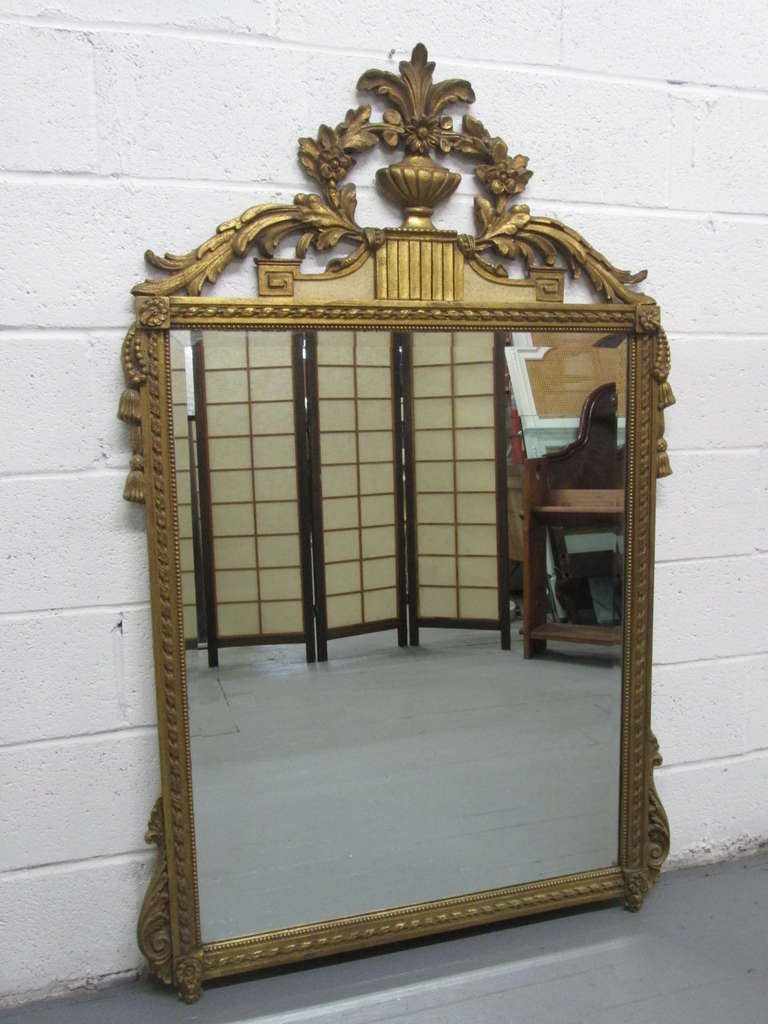 Gold Gilt Mirror with a carved frame and carved crest.   Mirror is beveled. 