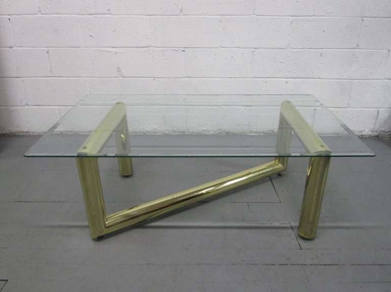 Tubular Brass Coffee Table with glass top in the manner of Karl Springer.  Glass has a beveled edge. Some scratches to the glass.