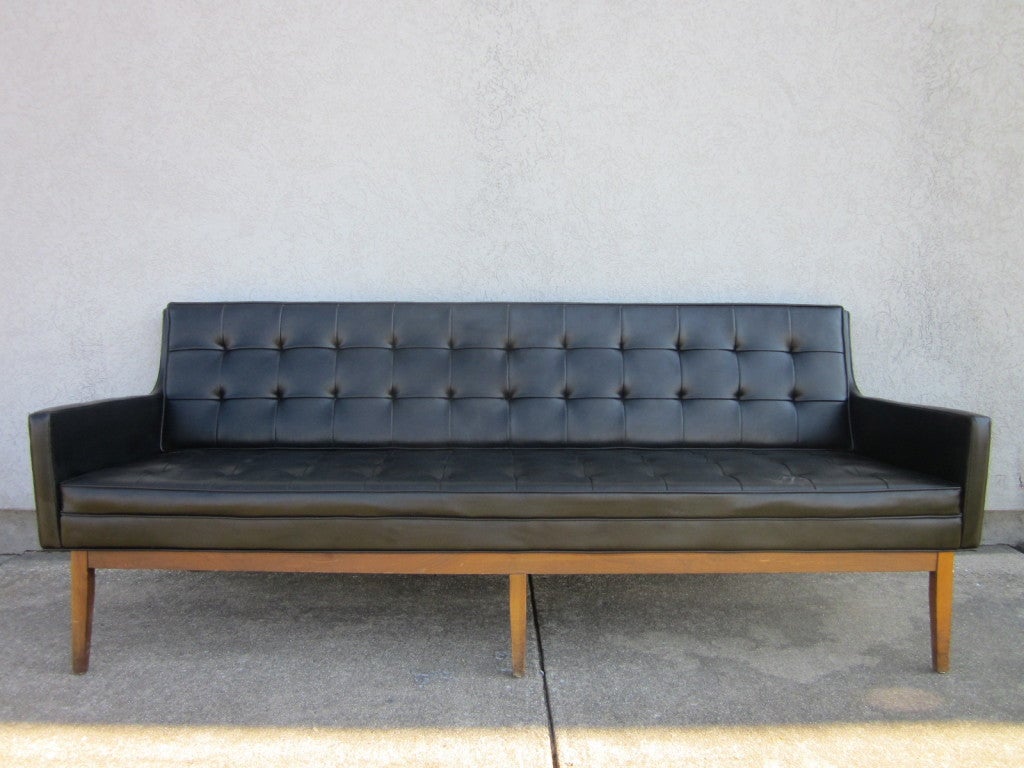 Knoll, tufted black naugahyde sofa with walnut legs.