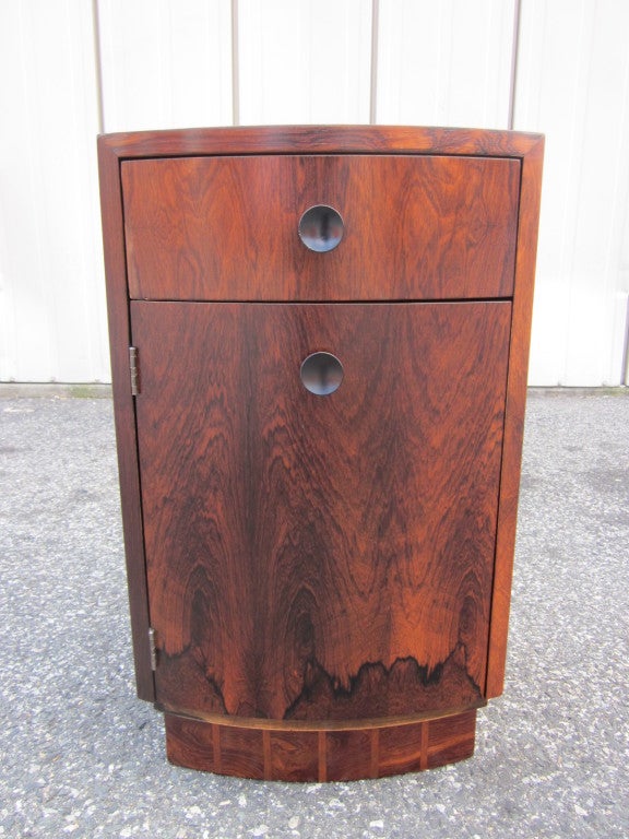 Pair of Gilbert Rohde rosewood nightstands.  Beautiful rosewood grain, a single pull out drawer and a cabinet door.