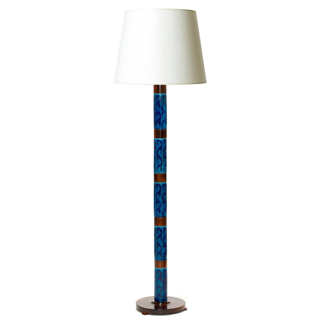 Rare model standing lamp with exceptional hand-painted blue-on-blue tiles alternating with sections of rosewood, with round palisander base, designed by Stig Lindberg (1916-1982) for Gustavsberg, Sweden, mid-20th century. (Note: The tiles are