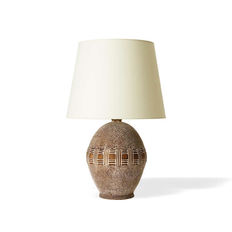 Table lamp in stoneware by Jean Besnard (1889-1958), with ovoid form, featuring a central band of a basket weave pattern in relief, with details picked out in white glaze, the majority of the body in “crispé” glazing, France, 1930s. “JB” monogram