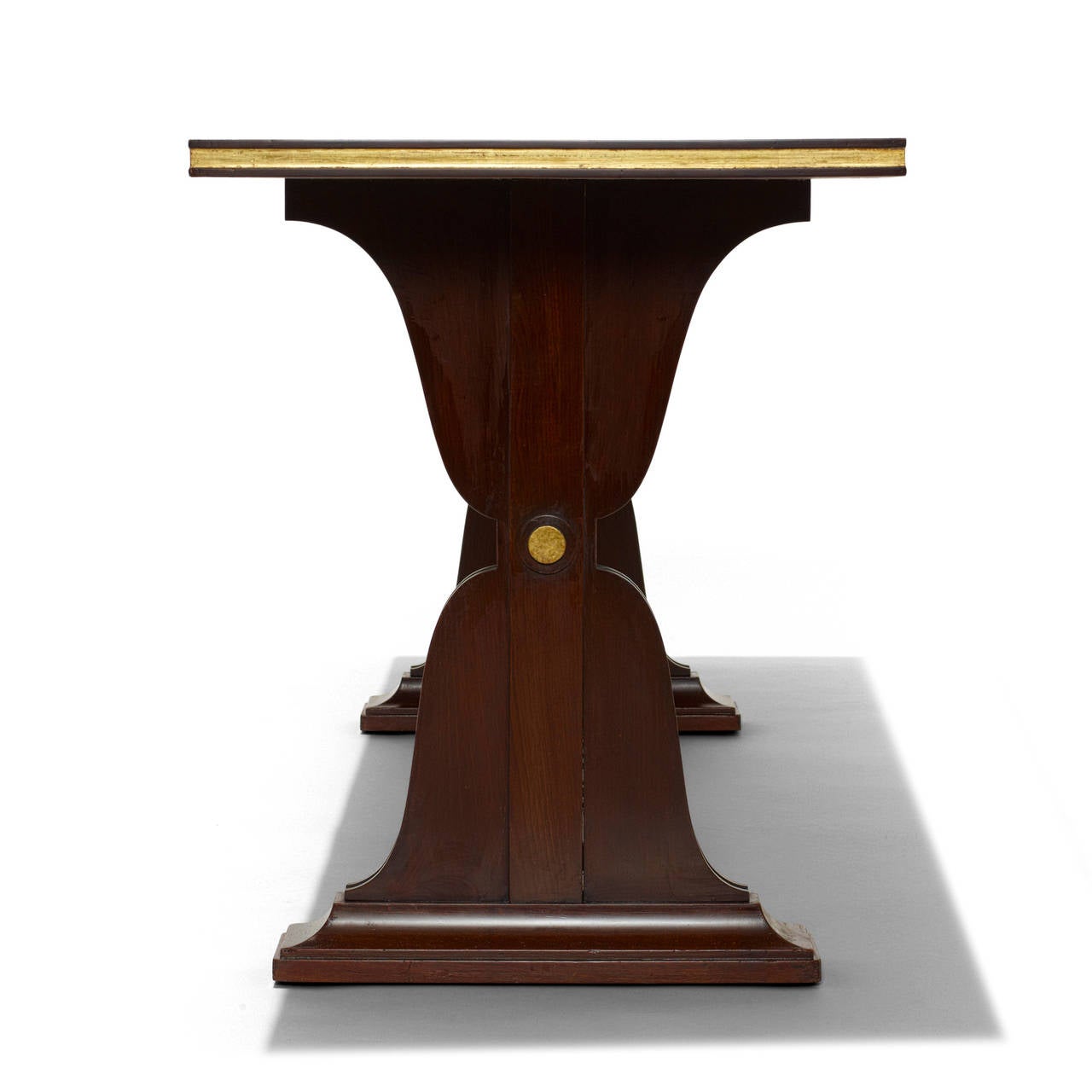 Console or sofa table by Maison Jansen, with hourglass or diabolo-shaped pier legs joined by a stretcher and terminating in mitered molding, in Cuban mahogany with partial gilding and brass hardware, France, 1930s-1940s.
Numbering “68599” impressed