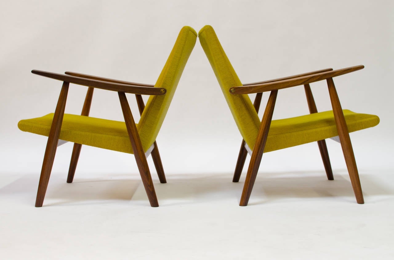 Offered is an exceptionally original pair of teak lounge chairs designed by Hans Wegner for GETAMA Gedsted model GE-260, dating to 1955. This design of the chairs is very good, with a nice swept arm and original hardware. The original fabric has not