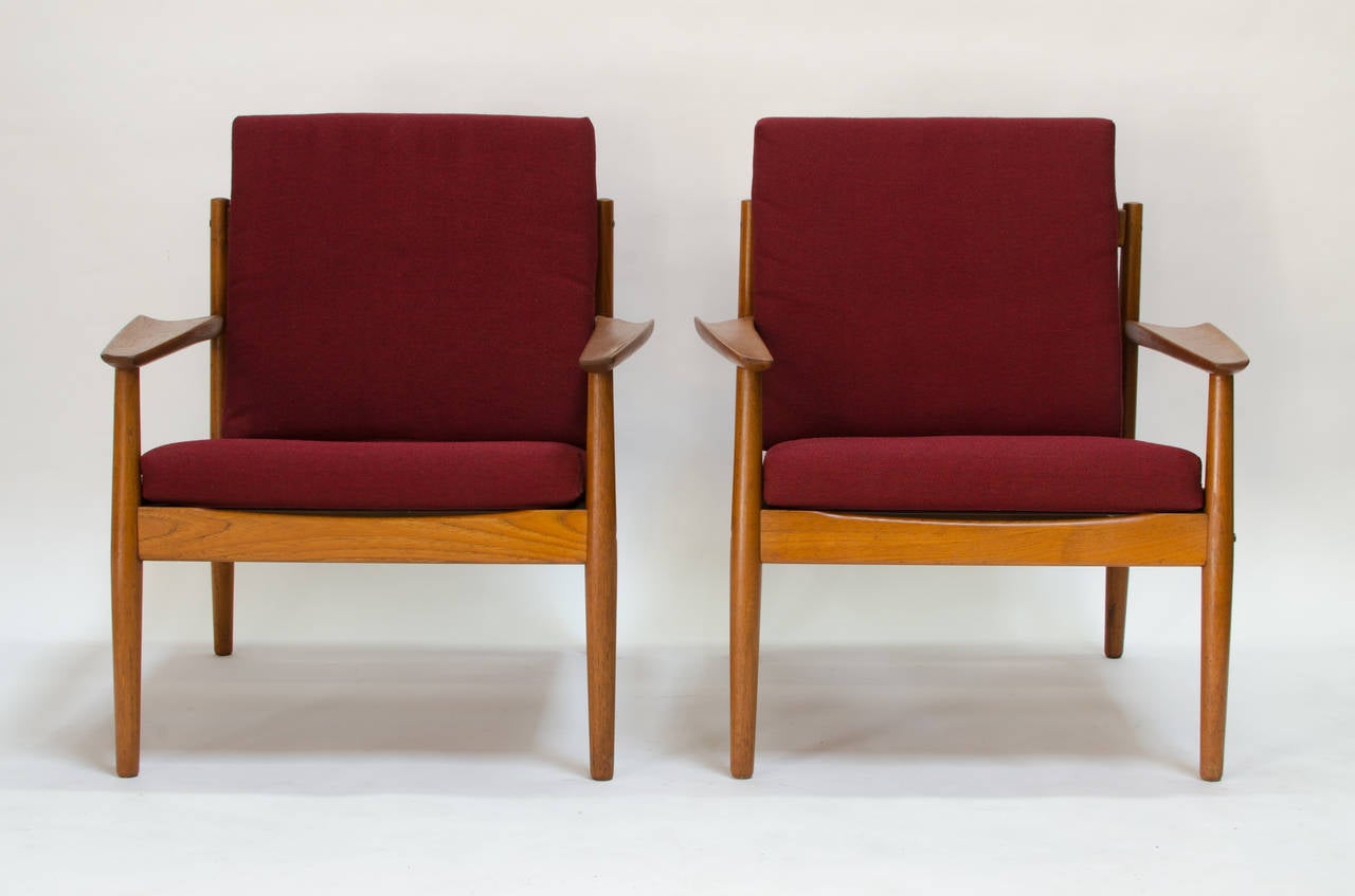 A pair of teak easy chairs by Arne Vodder for Glostrup. Vodder created a few pieces for Glostrup and they are all quite unique. The teak is gorgeous and has a beautiful grain. The organic shaped upward swept armrests are a beautiful detail not