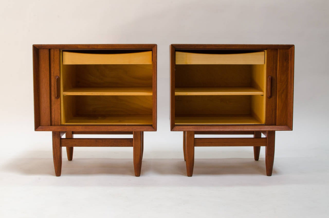 Pair night tables by Arne Wahl Iversen for Falster c.1958. Each has a tambour door which opens to reveal an interior drawer, and an open storage space with adjustable shelf. Solid construction and finished back.