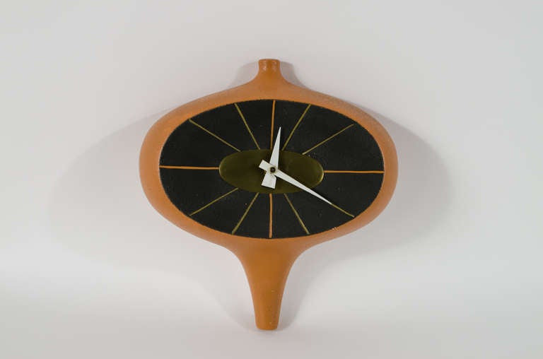 Amazing ceramic and brass hanging wall clock in the manner of George Nelson. This resembles a small line of ceramic prototype clocks, designed by Irving Harper and George Nelson that never went into production. New battery movement installed. Also
