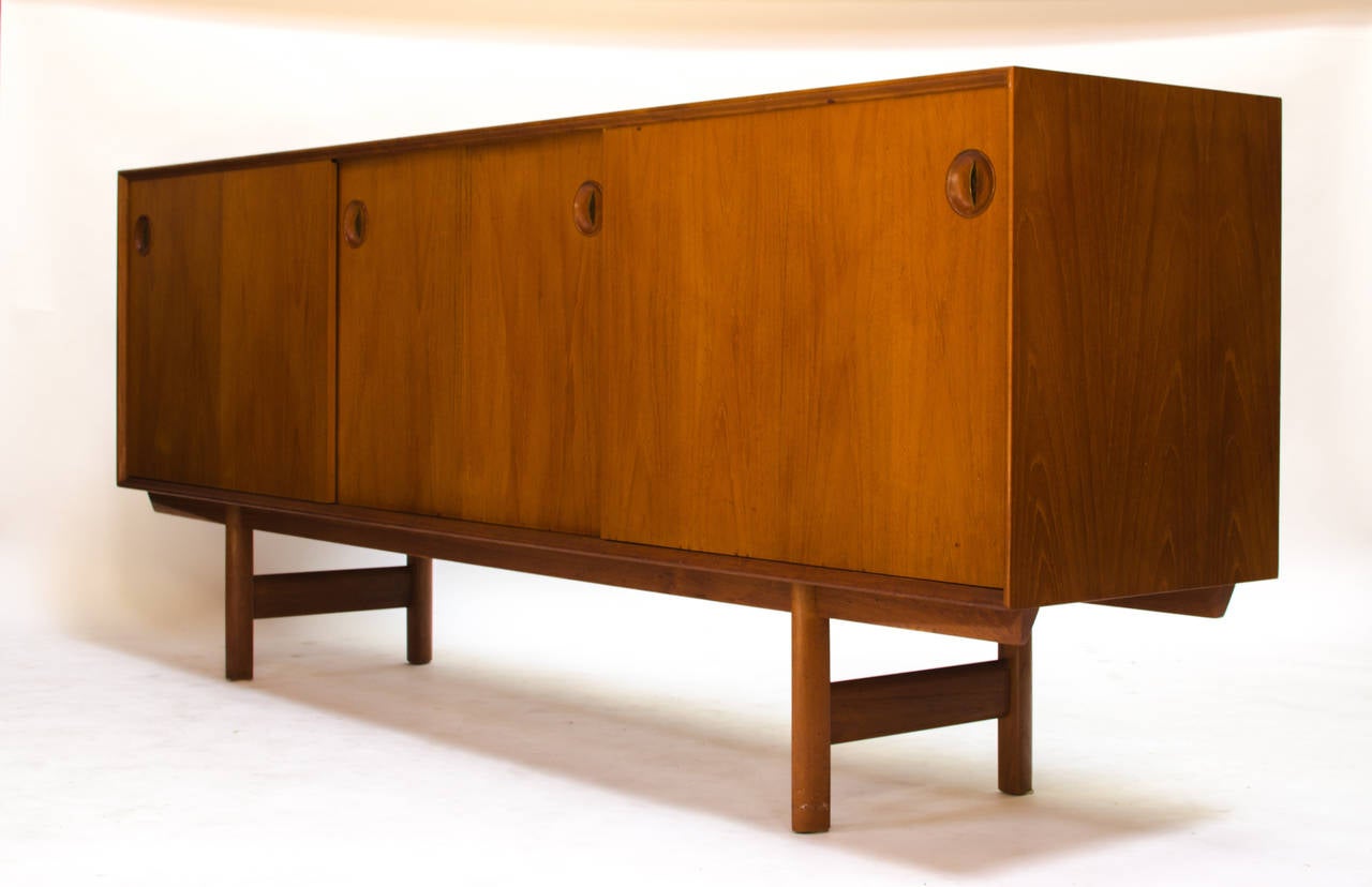 Truly stunning teak credenza or sideboard designed by Fredrik Kayser for Bahus Gustav, circa 1952. Of the highest craftsmanship, this credenza offers ample storage with drawers behind the right panel, and adjustable shelves center and left. This