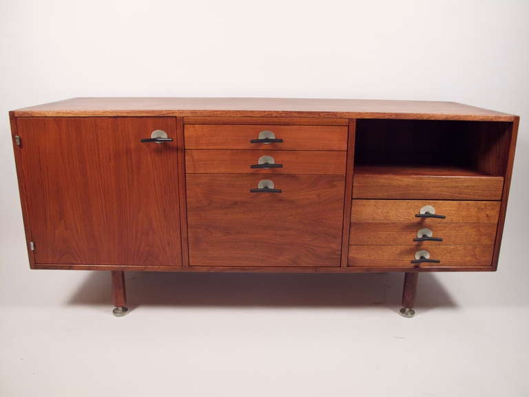 Stunning Jens Risom designed walnut credenza for Knoll c.1950's. Super cool t-pulls and adjustable feet. Most drawers have dividers and a pull out equipment tray. The back is finished so this can be placed anywhere in a room.