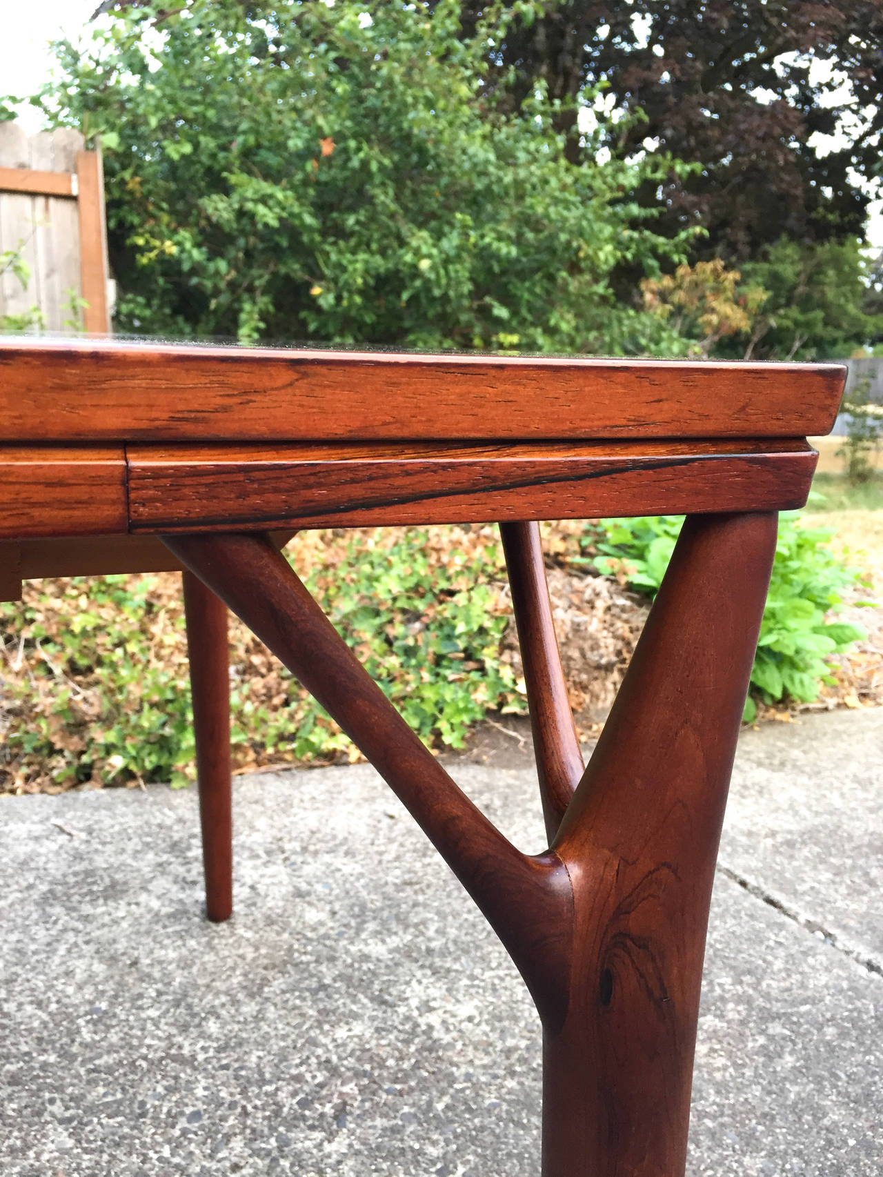 Amazing rosewood dining table designed by Helge Vestergaard Jensen c.1960s. Beautiful sculptural lines with dramatic rosewood grain. Table does have one leaf. Measurements with leaf: 93.5