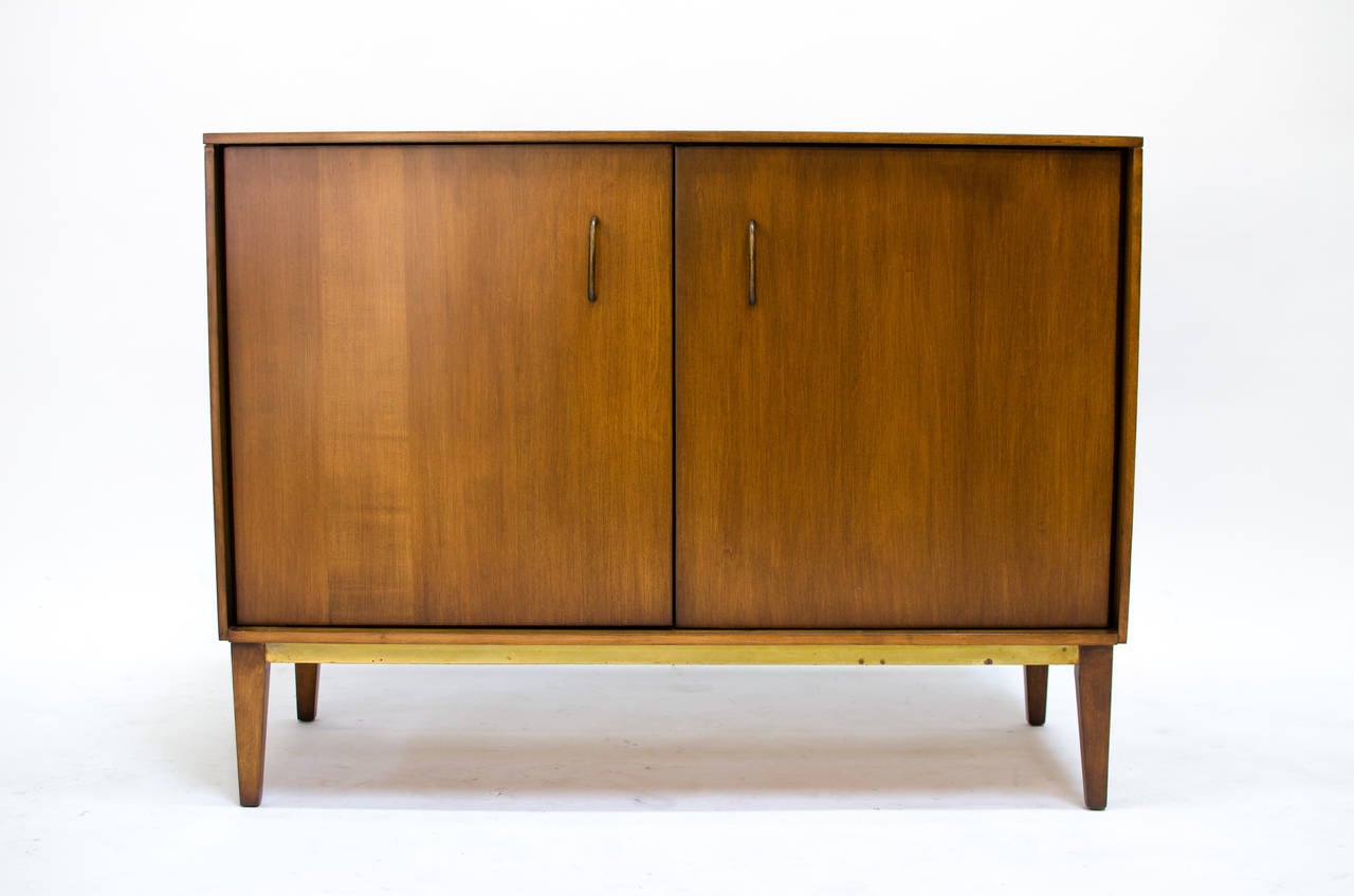 Stunning two-door cabinet designed by Milo Baughman for Murray Furniture. Amazing solid wood construction with beautiful brass details. Inside has ample storage room with two black sliding drawers. 