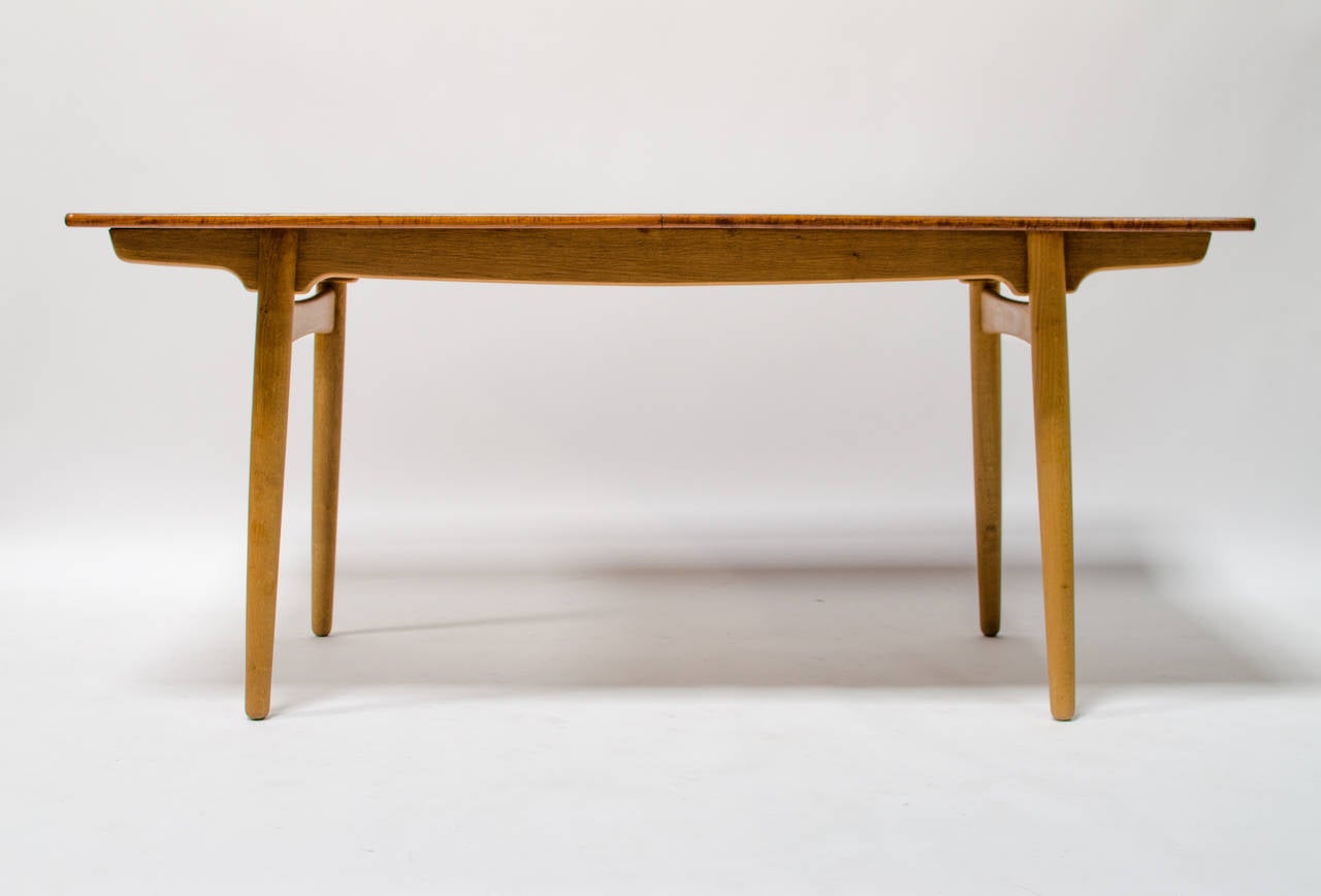 A rare and unusual Hans Wegner dining table for Andreas Tuck, circa 1955 Model -AT 310. This table has solid oak legs and base, with a teak top in very good vintage condition. A rare model, it is more narrow at 34” wide, than other similarly