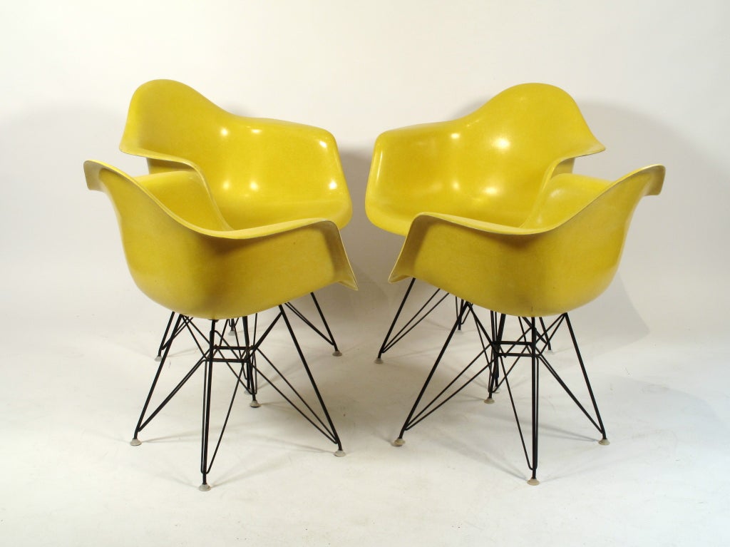 Rare set of 4 sunshine yellow arm shells with original black eiffel bases designed by Charles Eames for Herman Miller. Price is per each chair.