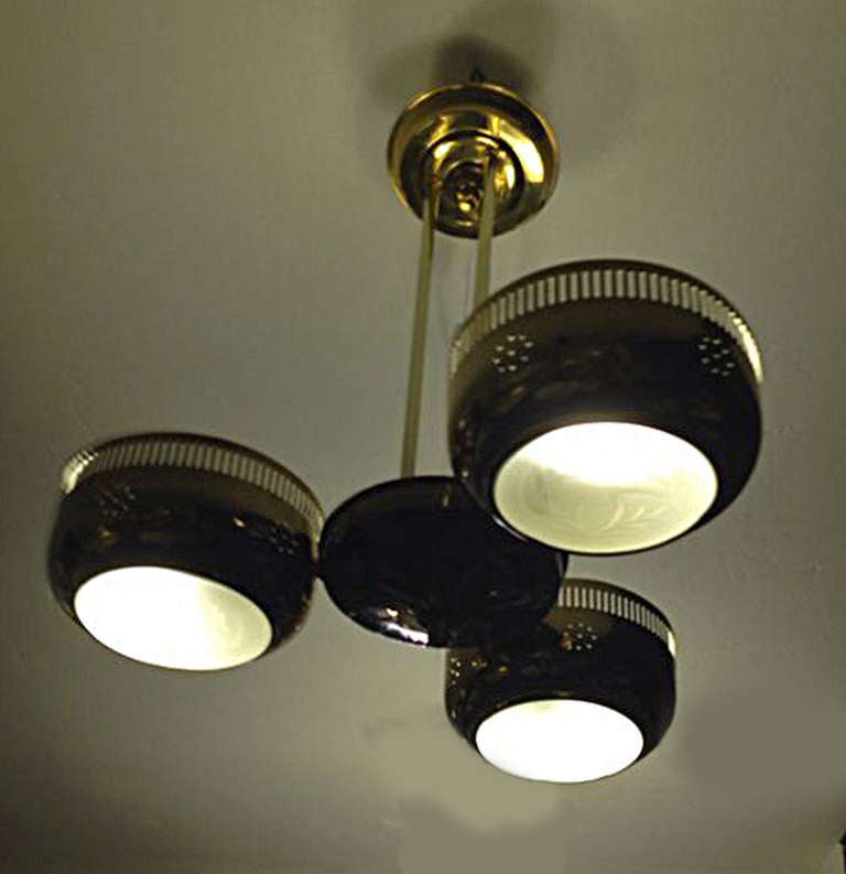 Pierced brass ceiling lamp in the style of Paavo Tynell.  With 3 carved glass shades.