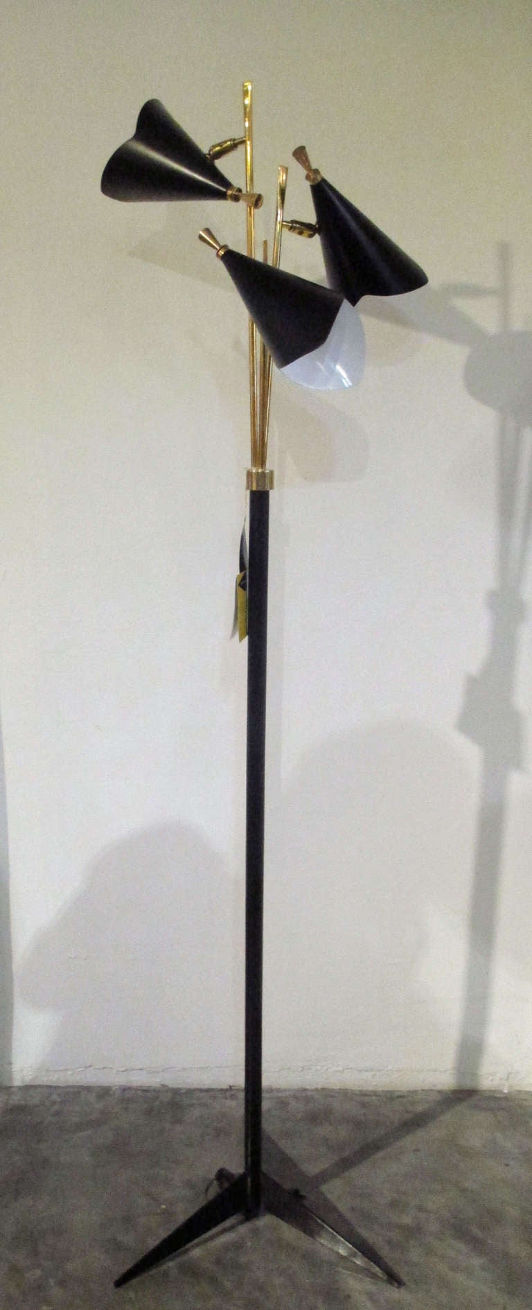 Lightolier floor lamp after Gerald Thurston. Made of metal, three movable shades, with original tag.