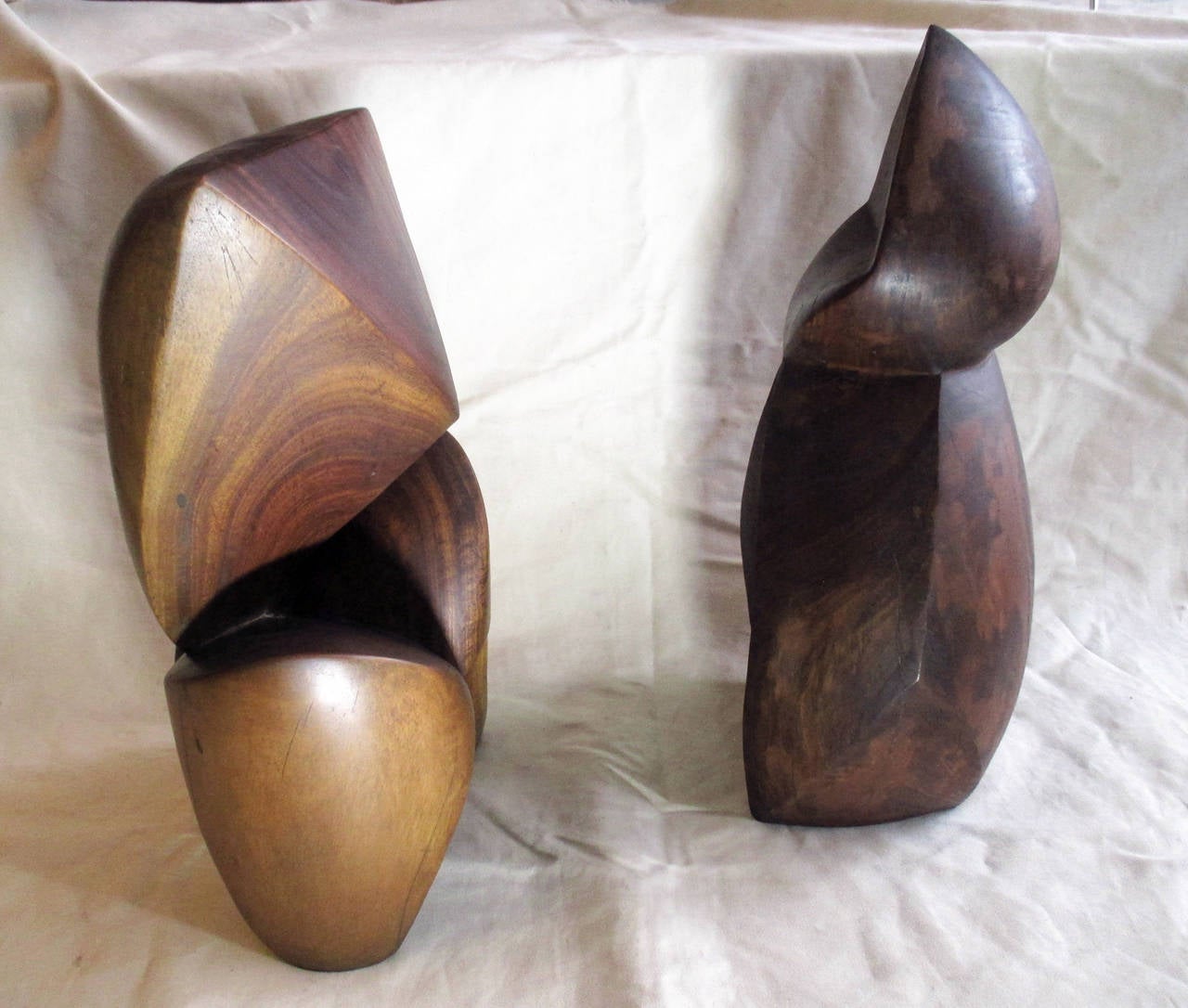 Two abstract wood carved sculptures by unknown artist. Each piece carved of a single trunk of tropical wood.  
Triangular sculpture is 52cm height, 29cm width, 22cm depth.
Circular sculpture is 55cm height, 30cm width, 23cm depth.