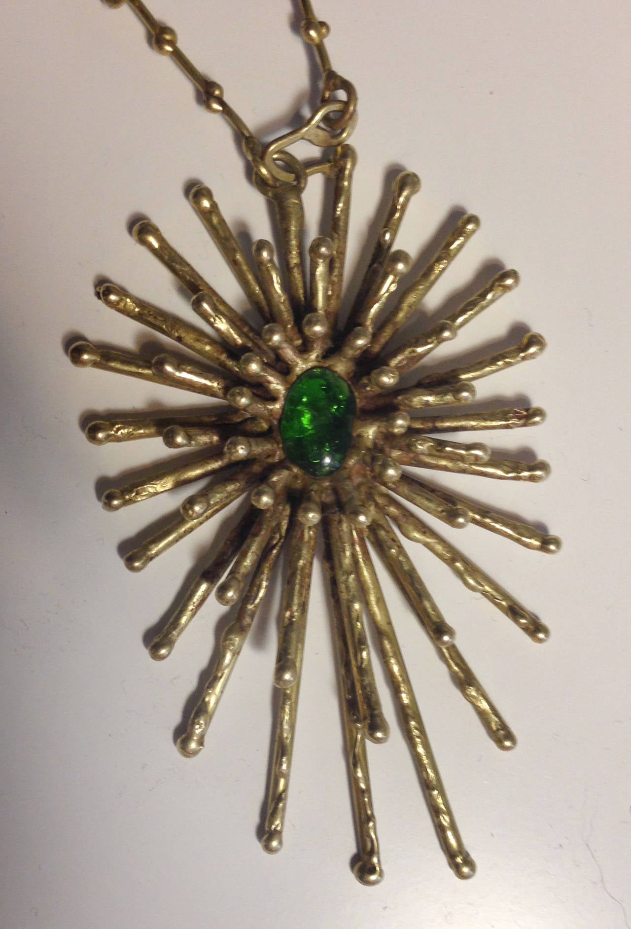 Beautiful Pal Kepenyes sunburst brass necklace with green blown glass.
Pal Kepenyes is a Hungarian sculptor, he is now living in Mexico since the 1990s, he is well-known for working with materials like brass, bronze, copper, silver and gold.