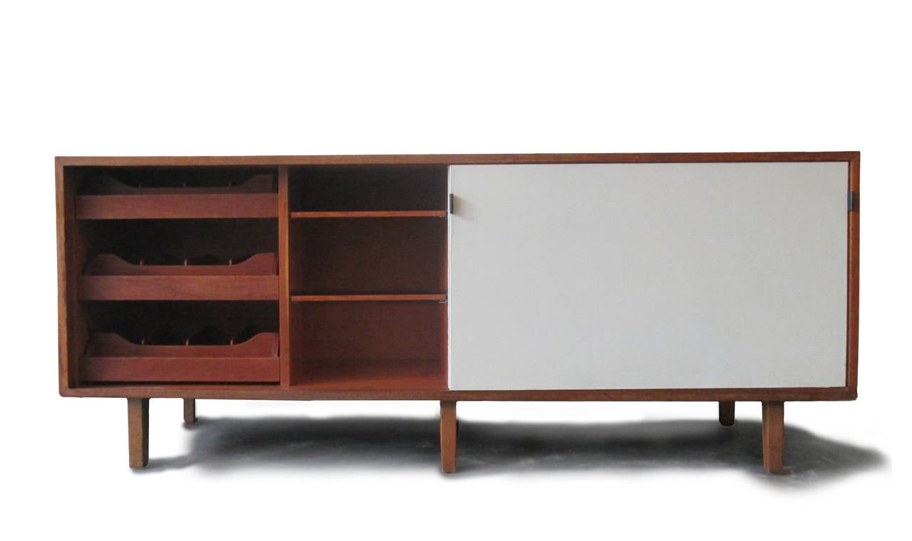 Early Florence Knoll credenza made of mahogany, wood square legs, two sliding doors and leather pulls. 

We have two available.