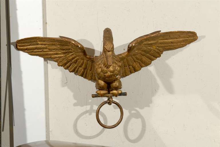 Early 19th Century French Empire Period fine quality gilt wood carved bird, perched with wings spread and holding a drapery ring.
