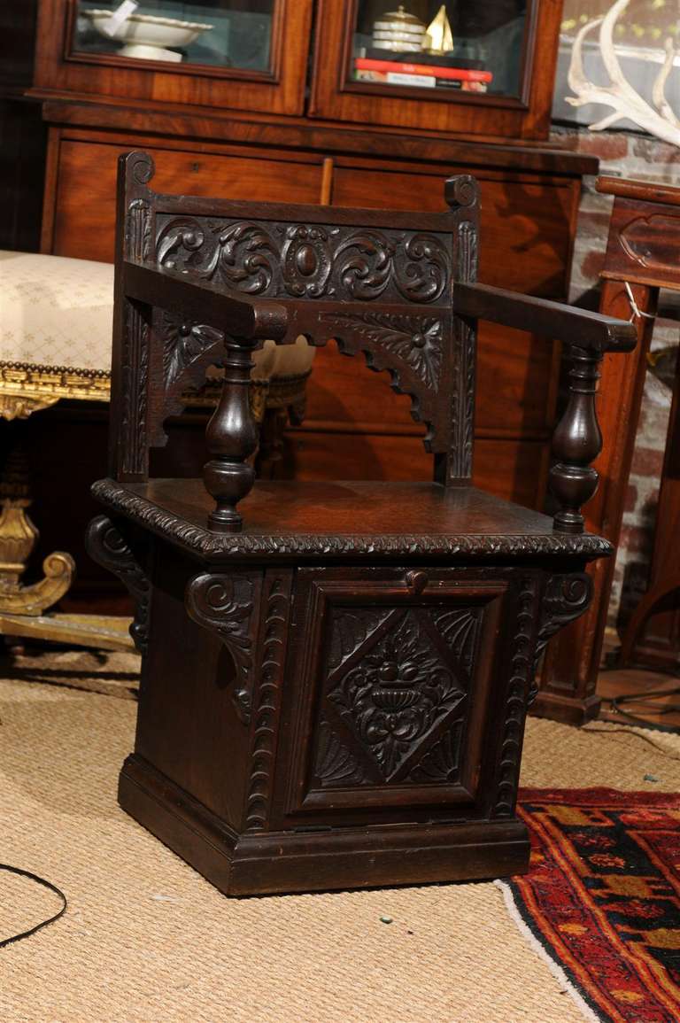 19th Century Italian Renaissance Revival carved oak cabinet chair with built in coal hod (and original liner) beneath the seat.   This chair is one of few surviving examples, as these chairs served a utilitarian purpose residing fireside and storing