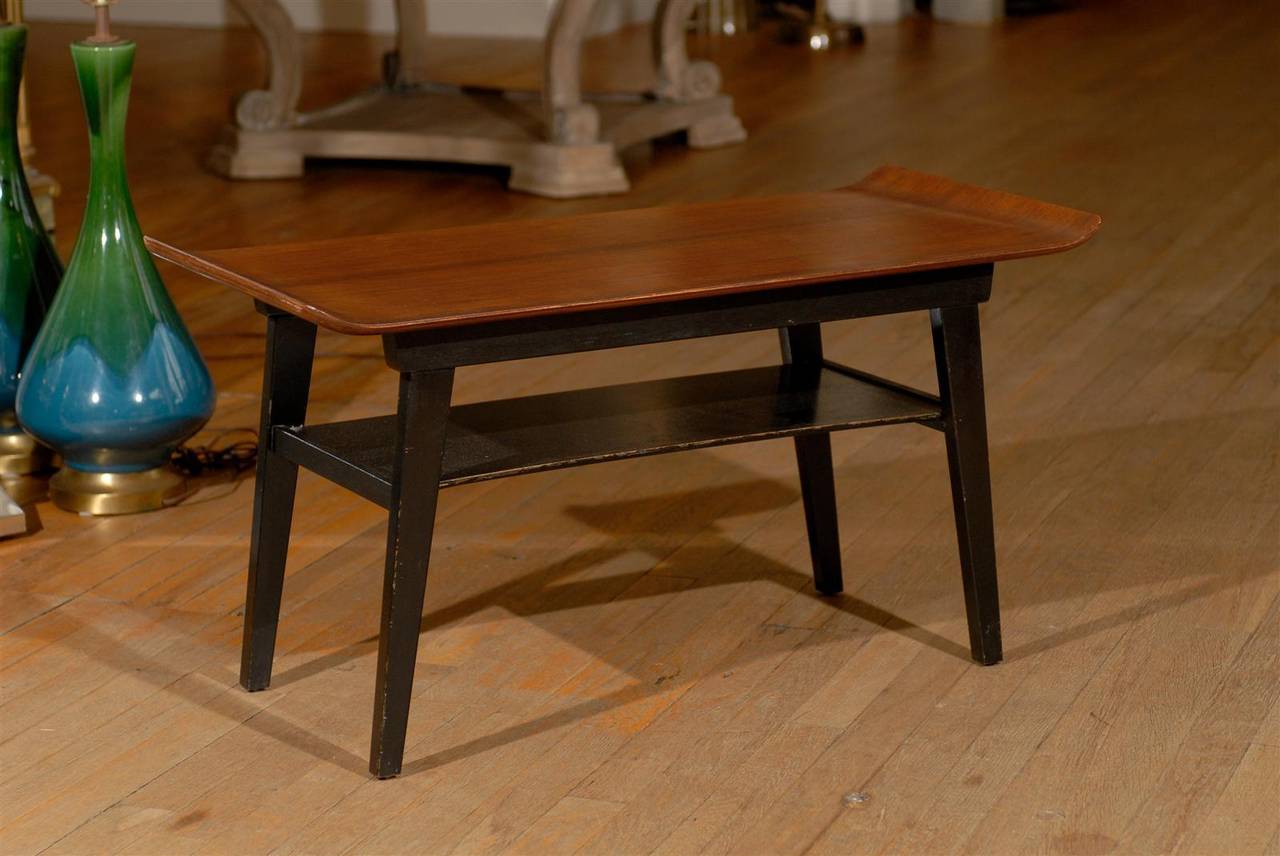 Mid century coffee table or side table with a bentwood top having upturned ends on an ebonized base with shelf and supported by tapered legs.