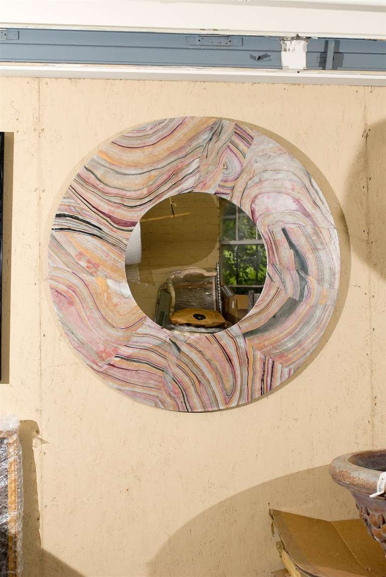 20th Century circular mirror with a wide faux marble frame painted in rich hues of magenta, gold, navy, and white.  Gilded veining though out.