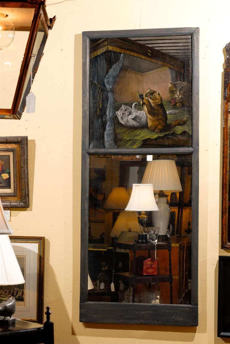 19th Century French trumeau mirror in a gray painted frame with a primitive painting of kittens batting at drapery tassels with the mother cat watching in the background.