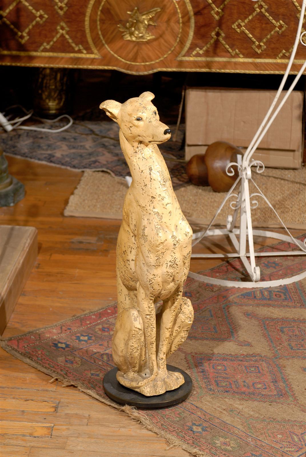 Hollywood Regency plaster statue with a pitted stone like finish of an Italian Greyhound or Whippet mounted on a circular iron platform base.