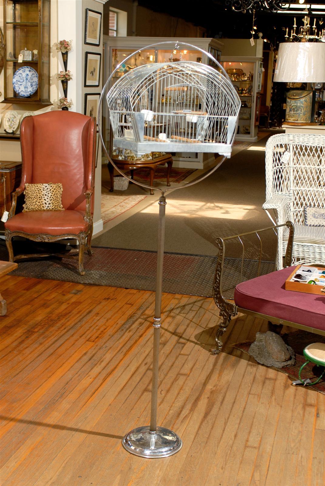 20th Century American chrome plated bird cage suspended from a hoop floor stand.  The bird cage was made by Hendryx during the Art Deco period and can be used with or without the stand.