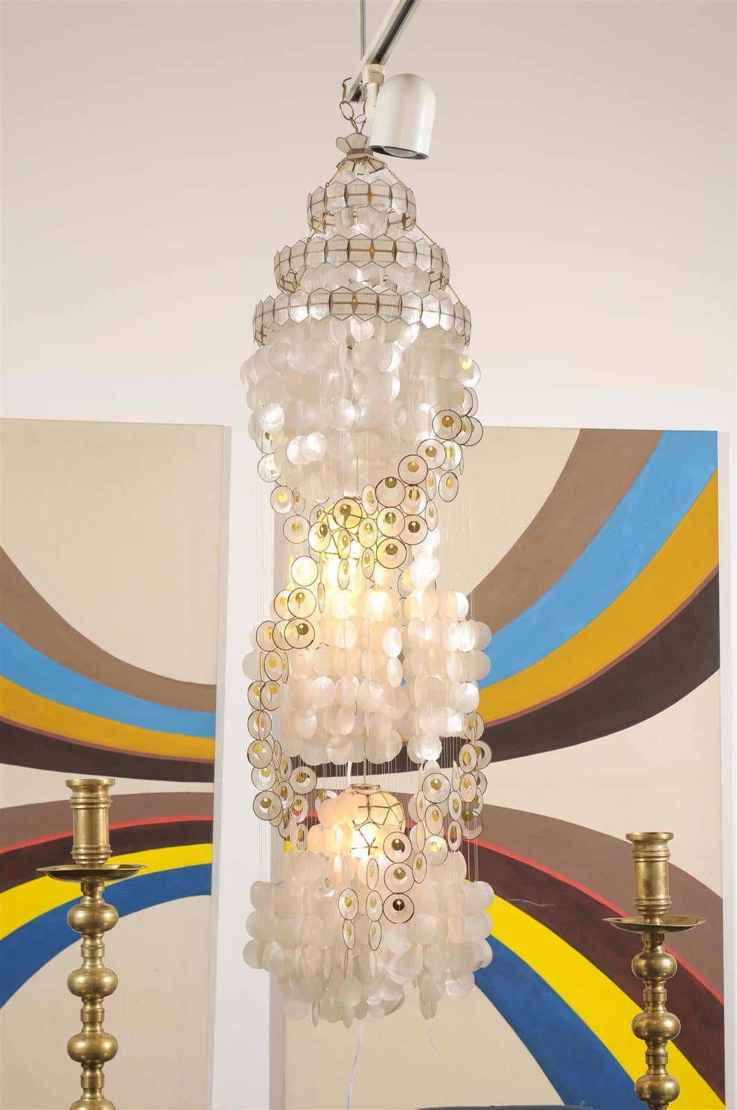 Tall vintage capiz shell chandelier of white with gold accents and having two interior globes holding lights. The light has been rewired.
