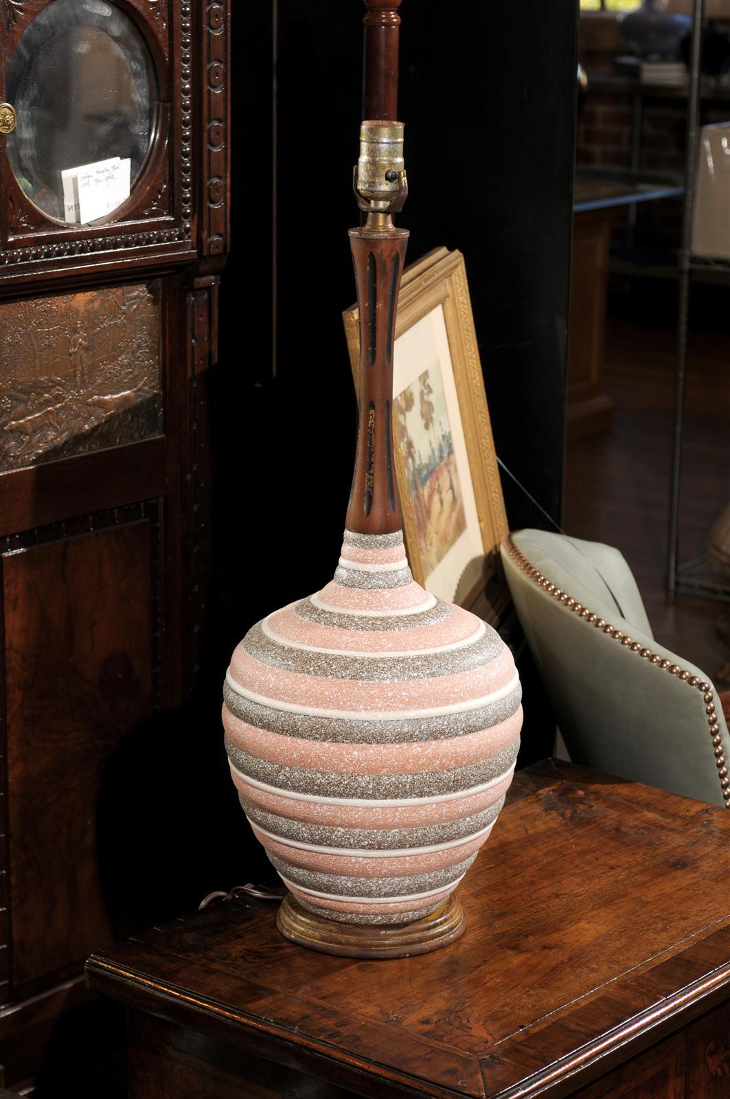 Midcentury urn shaped wood and ceramic lamp. Neck and base are in walnut. Body of lamp is ceramic consisting of alternating rings of raised pink, brown, and white crater glazed bands.  