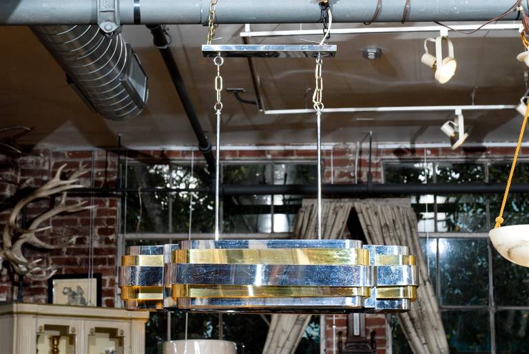 Mid-Century Modern light fixture of brass and chrome. There are five available for sale.