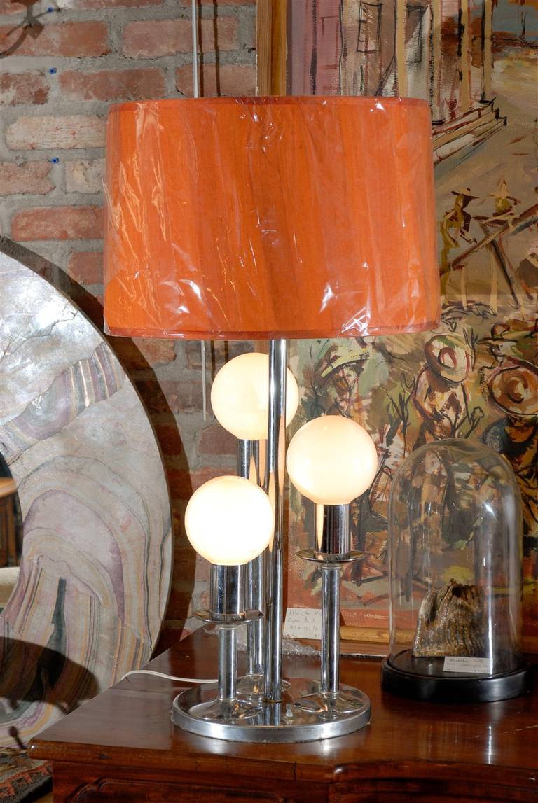 Mid-Century Modern lamp of chrome over three graduated round frosted bulbs on a platform base. Lampshade not included in price.
