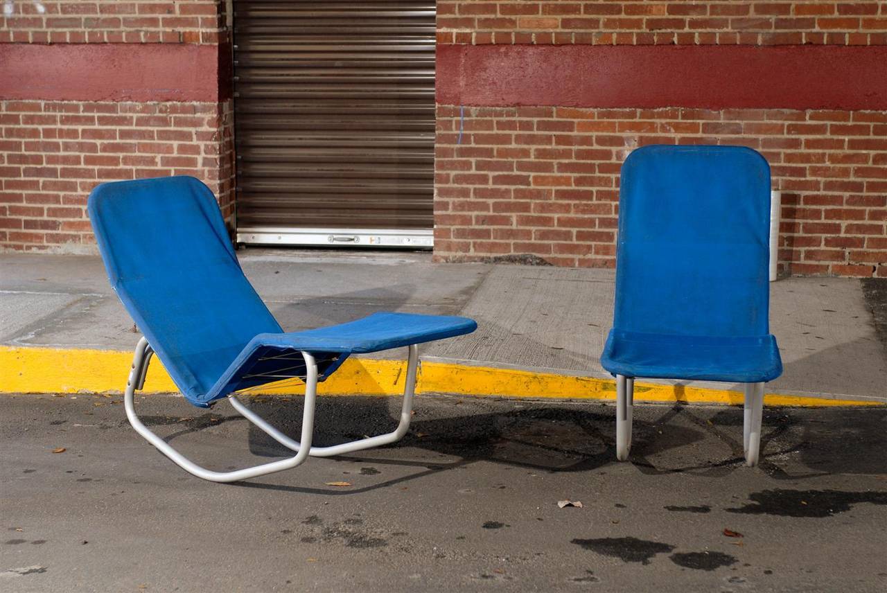 20th century pair of matching blue Barwa chaise lounge chairs by Edgar Bartolucci and Jack Waldheime, each having a tubular aluminum metal frame with spring tension supporting a heavy blue canvas upholstery.  Perfect for indoor or outdoor use.