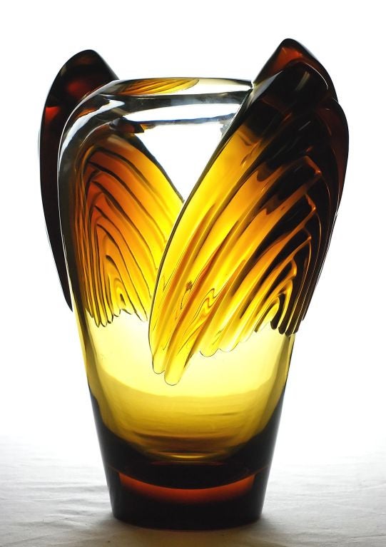 Lalique Art Deco Marrakech Vase. Amber-colored art deco vase with a label reading “Cristal Lalique Paris.” Deco-style appliques on each shoulder. Underside engraved “Lalique  France.”