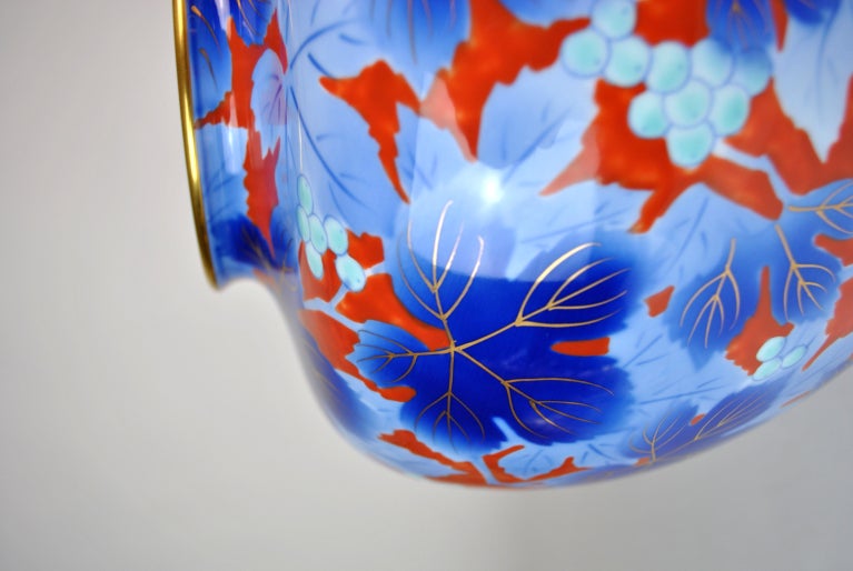 Japanese Porcelain Vase by Fukagawa. A bulbous vase decorated in gilt and orange florals and teal berries on a blue ground. Marked on the underside with the silver and blue Fukagawa foil label reading â??Fukagawa/Porcelain/Arita/Japan/Purveryor to