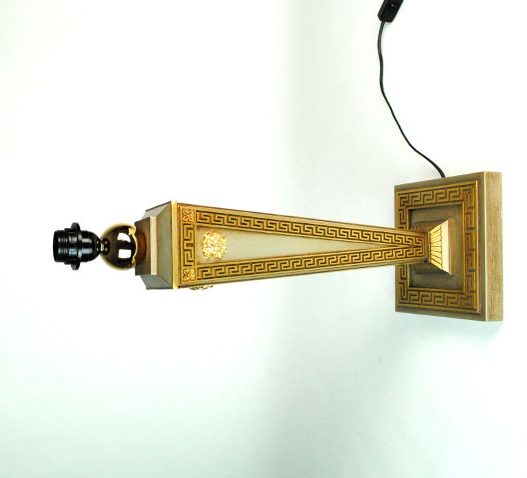Versace Goldplated Table Lamps. The geometrically-tapered stem is decorated with the Versace face logo and a Greek key frieze on each of its four sides. The base is square and with a conforming Greek key border. European-wired.