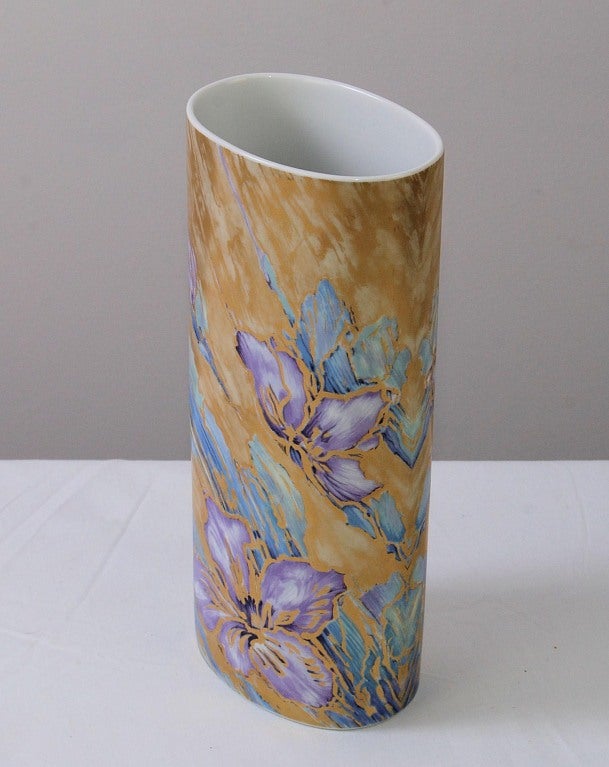 Cylinder-Form Porcelain Vase by AK Kaiser. A cylinder-shaped vase by AK Kaiser Porcelain (1970-present). Decorated in purple orchids and blue strokes on a gilt ground. Designed by K. Nossek. Marked on the underside with the blue AK Kaiser crown