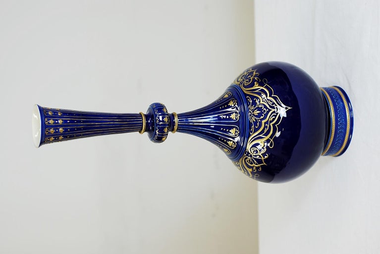 Vase italien par Ermete Agostinelli. Produit à Bassano, en Italie, par le Dr Ermete Agostinelli (1915-2000). Une tige effilée de forme cylindrique et une base bulbeuse. Décor de feuilles et de rinceaux dorés sur fond bleu.