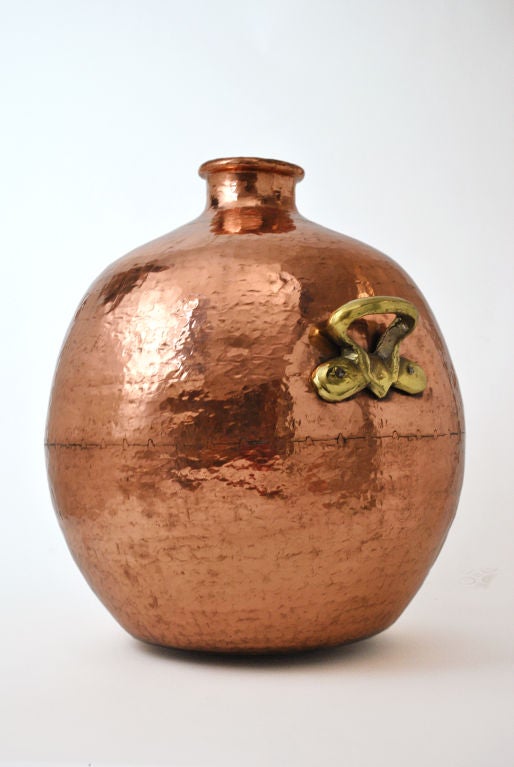 Monumental Copper Vessel. This large copper vessel has a hammered body and is fitted with twin brass handles. It is meticulously assembled from three parts with an identifiable seam separating the lid, body, and base. Mentioned in religious,