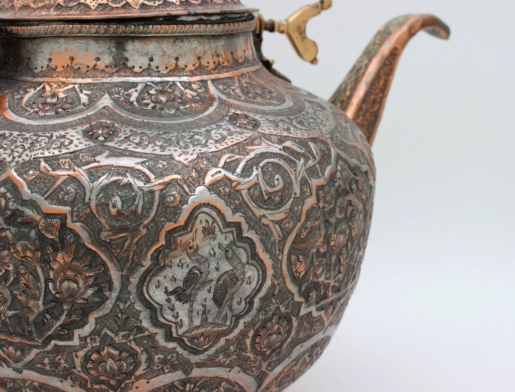 Antique Persian Copper Teapot. Copper teapot decorated with embossed and engraved scrolls and flower motifs along with several figural birds. Attached handle with wooden hand-hold. Lid is also embossed and engraved but with leaves and a geometrical