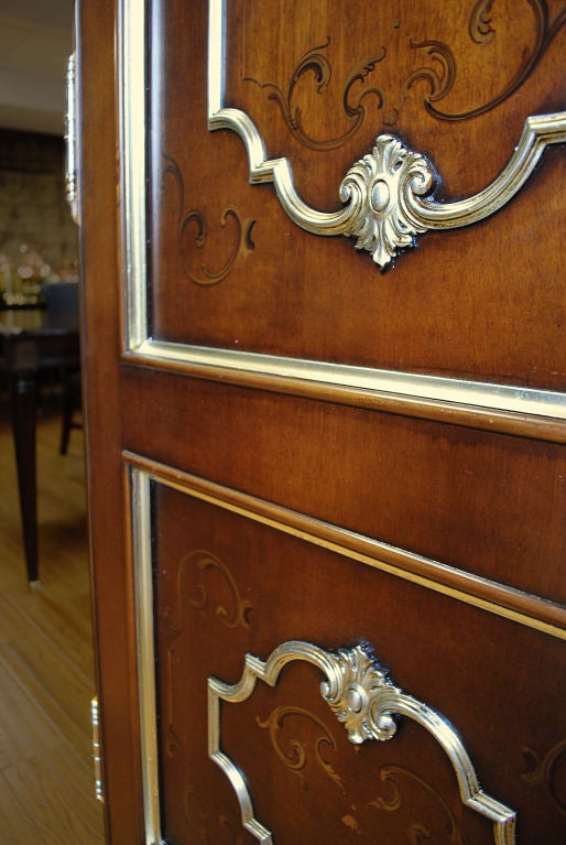 Continental Boiserie Style Door. A two-panel boiserie style door decorated on each side with gilt painted scrolls and a large applied chrome medallion-form within each panel. Chrome  handles and fittings with large keyhole. Boiseries were popular in