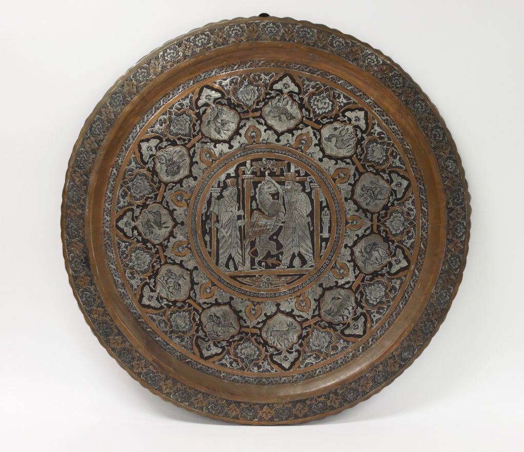 Monumental Charger With Inlaid Scene of Persian King Confronting Ahriman the Mythological Zorastrian Demon. The central focus of this large and intricately inscribed circular tray is an inlaid copper and silvered scene depicting a Persian King in an