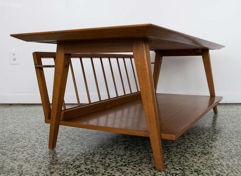 Very nice blonde midcentury coffee table with extended magazine rack in the style of Brown and Saltman.
