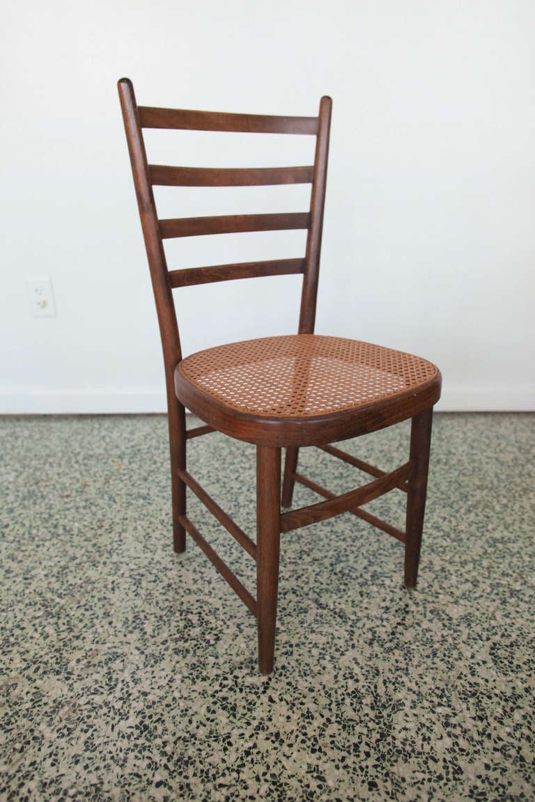 Six mid-century ladder back dining chairs with wicker seats in the style of Gio Ponti.