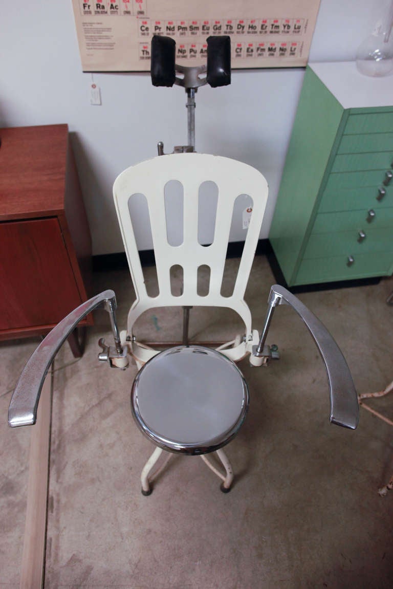 Antique Metal Dental Medical  Chair circa 1920s industrial dental chair. 
All metal adjustable dental chair with ead pads, adjustable arms and seat, and reclining back. Chrome and white.